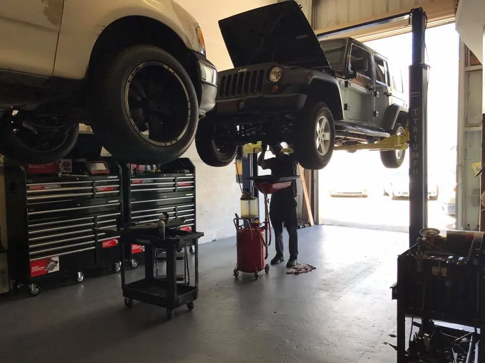 Two vehicles up on lifts in the shop